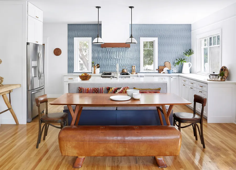 Finished kitchen with blue tile backsplash and wood dining table