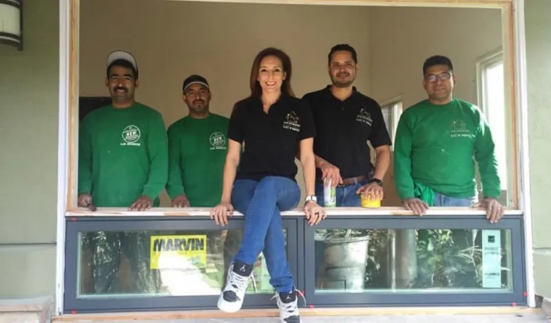 The New Generation crew standing in a framed window opening