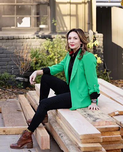 Marisela Arechiga seated on stacked lumber at a jobsite